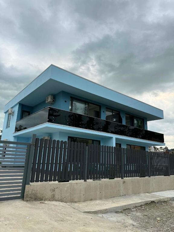 a blue house with a fence in front of it at Sunset paradise in Ureki
