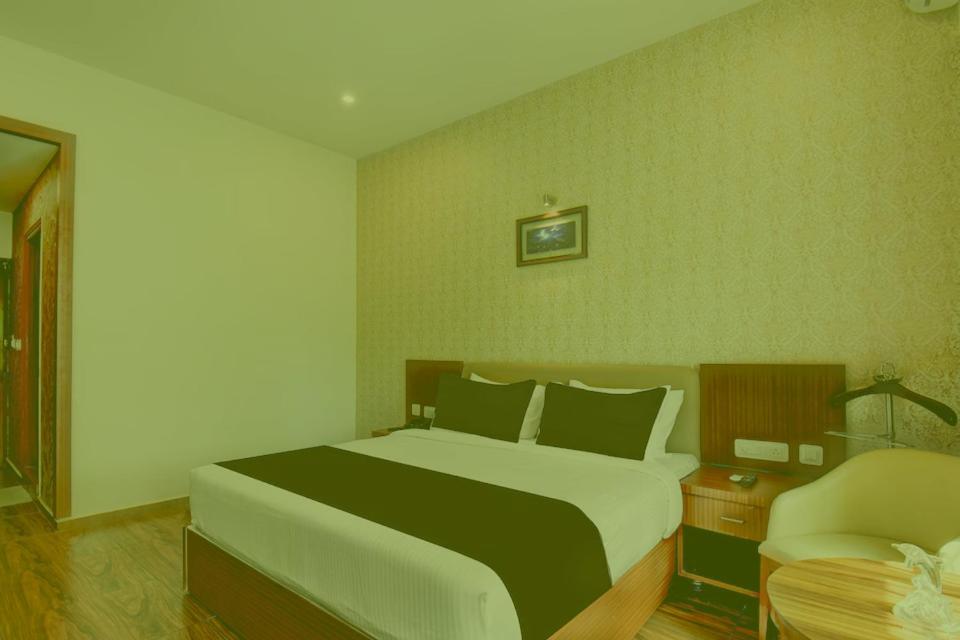 a bedroom with a large bed and a chair at Prabin Ghatiya Homeinn in Patna