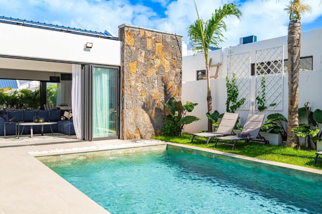a swimming pool in the backyard of a house at Villa Solis - Elegant & Modern Private Pool Escape in Cap Malheureux