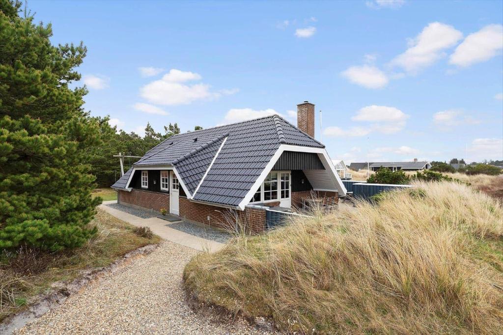 a house with a metal roof on top of a hill at 146-Ringkobing-Hvidbjergvej-23 in Søndervig