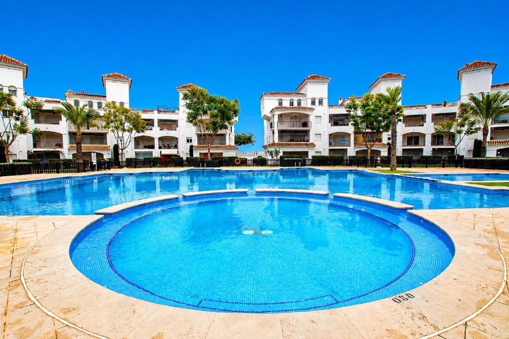 a large swimming pool in front of a building at Adosado Roldán by Rental Olé in Roldán