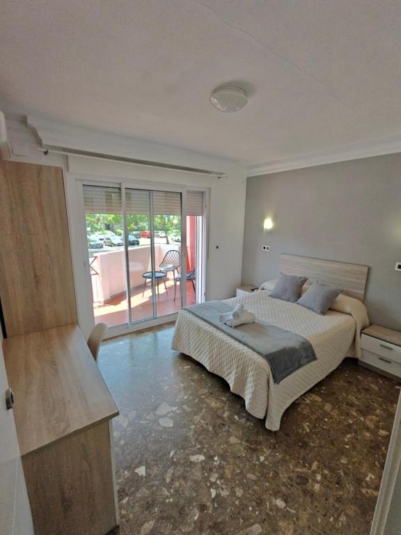 a bedroom with a bed and a door to a balcony at AYAMONTE ROOMS 43 in Ayamonte
