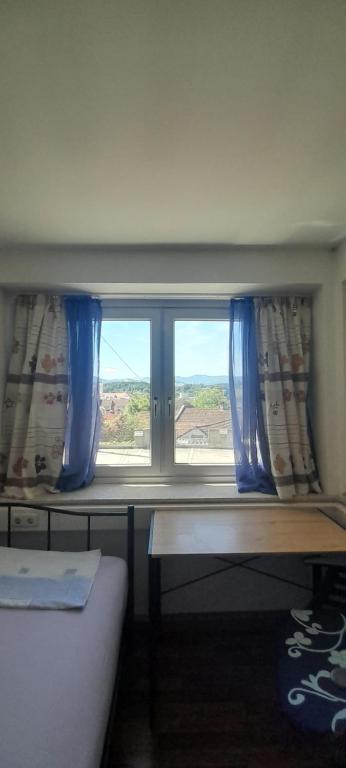 a bedroom with a window with blue curtains at Ela Gar 3 WG Zimmer in Garsten