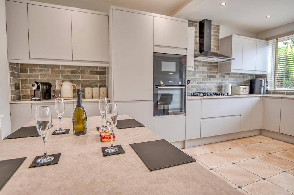 a kitchen with a table with wine glasses on it at Finest Retreats - Dockyard House in Pembroke Dock