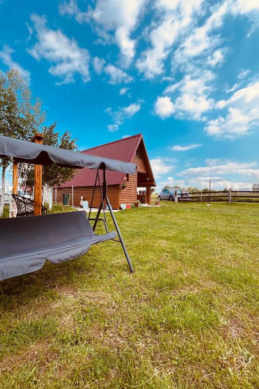 a hammock in a field in front of a house at Durmitor Hideaway in Žabljak