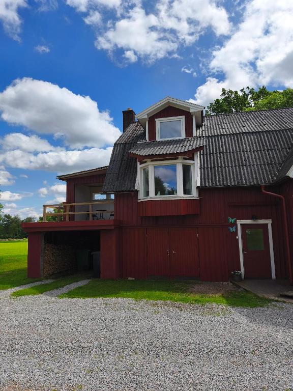 a red house with a red fence in front of it at The Colored Butterfly in Månstad