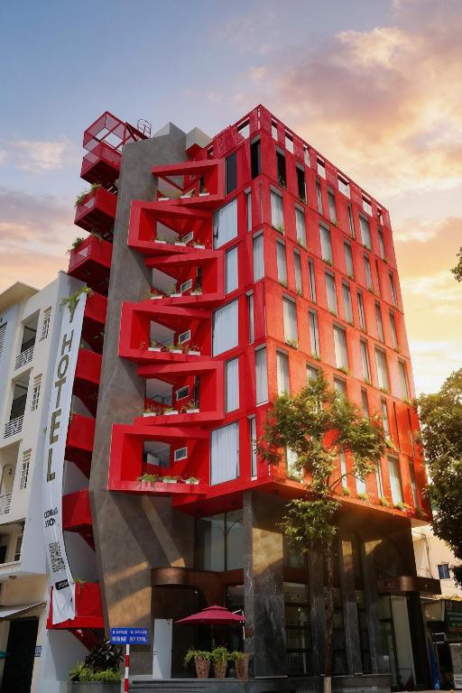 a red building with balconies on the side of it at Y Hotel Phan Đình Phùng in Can Tho