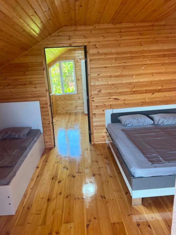 a room with two beds in a log cabin at Cottage Sandro in Kobuleti