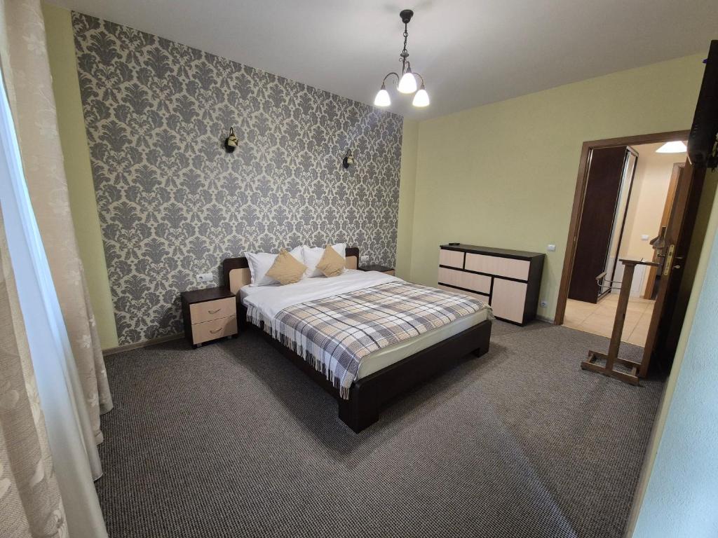 a bedroom with a bed and a wall at Княжий двір in Yaremche