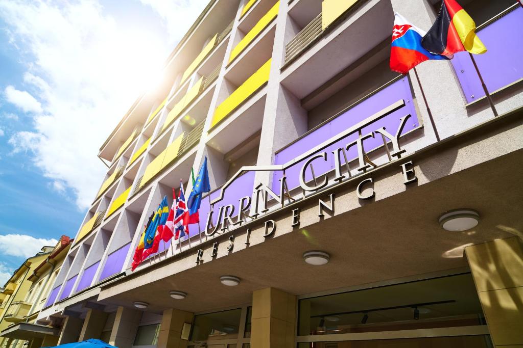 a facade of a hotel with flags on it at Hotel Urpín City in Banská Bystrica