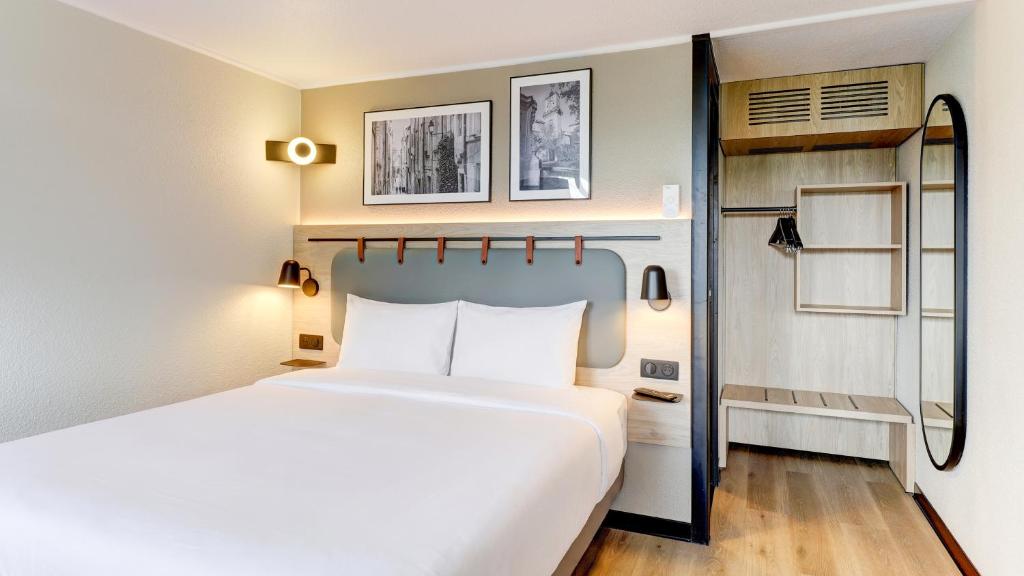 a hotel room with a bed and a closet at Campanile NATURE - Moulins Avermes in Avermes