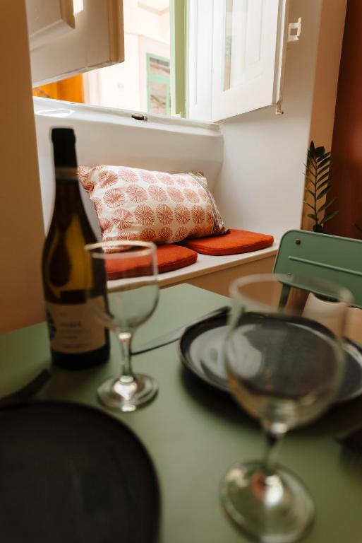 a kitchen counter with two glasses and a bottle of wine at Ta' Dolor - Kalkara Heritage Maisonette in Kalkara