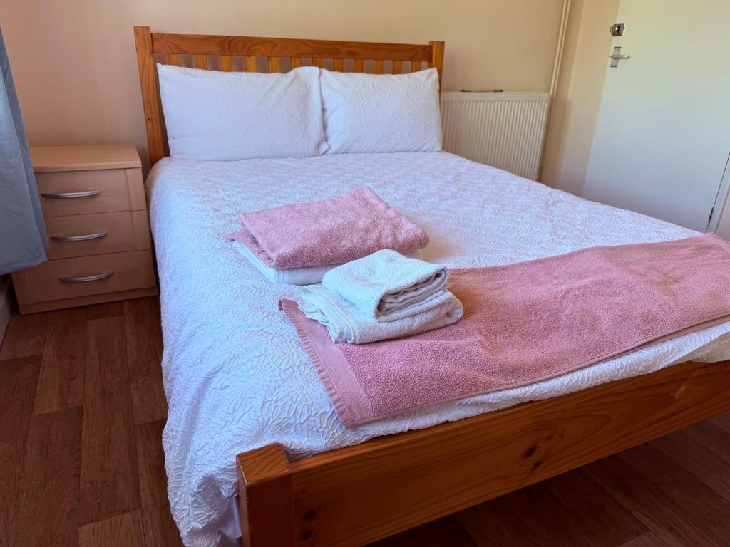 a bedroom with a bed with pink towels on it at Kirkar Flat in Penton Mewsey