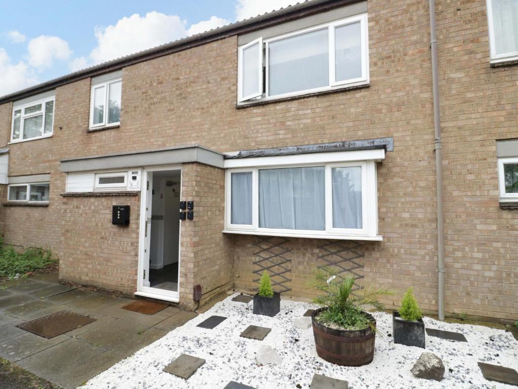 a brick house with white windows and a courtyard at Lodge Park in Corby