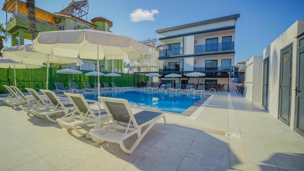 a group of chairs and umbrellas next to a pool at Blue Serenity Hotel in Side