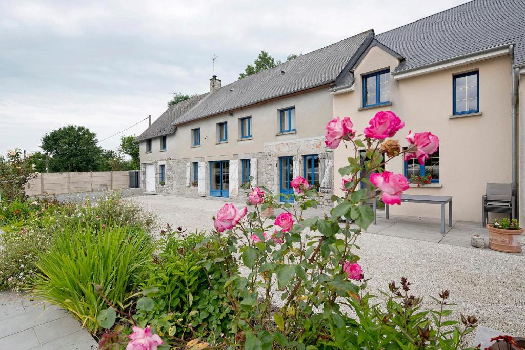 a house with pink flowers in front of it at Chambres D'hôtes - Les Vergers in Muneville-sur-Mer