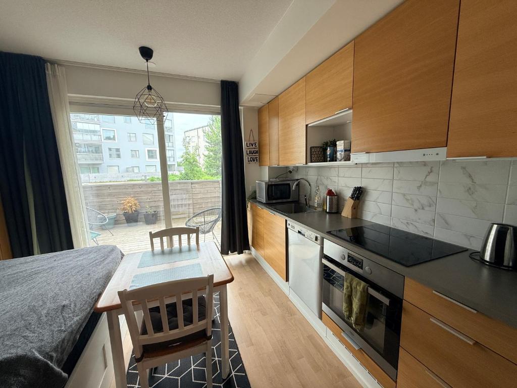 a kitchen with a counter and a table with a counter top at The Seaside Apartment Turku in Turku