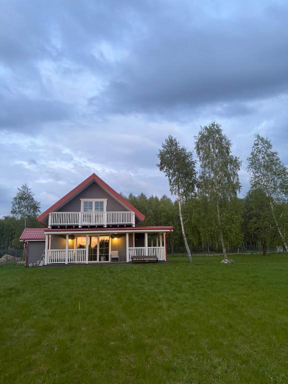 a house in a field with a large yard at Przystanek Dobra in Dobra