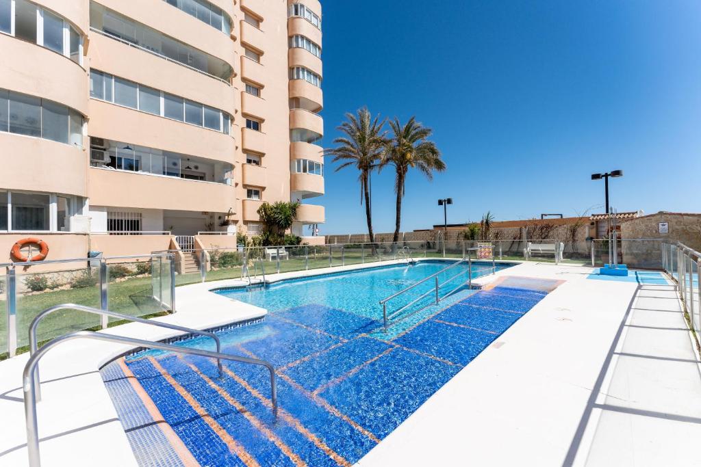 a swimming pool in front of a building at El Rey in Fuengirola