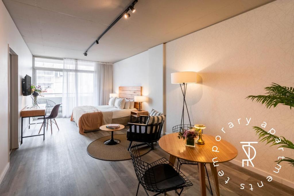 a bedroom with a bed and a table and chairs at Top Rentals Montañeses in Buenos Aires