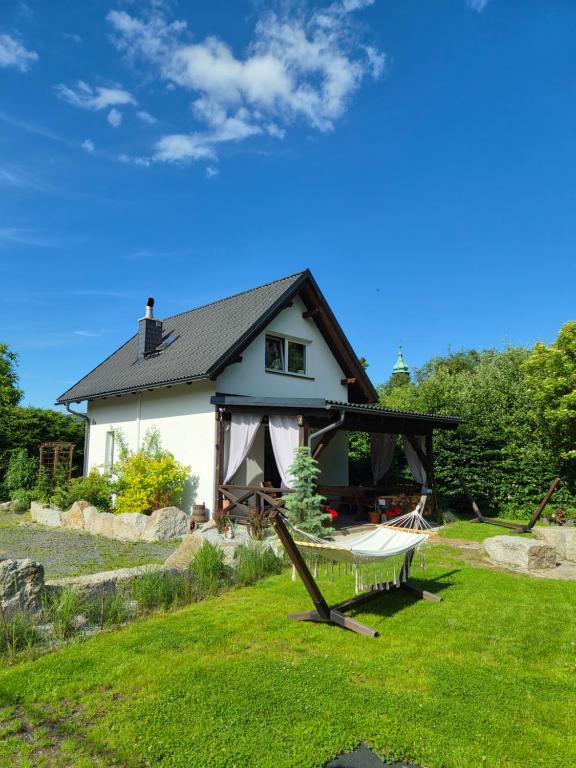 a house with a hammock in the yard at Domek Drwala k. Karpacza in Sosnówka