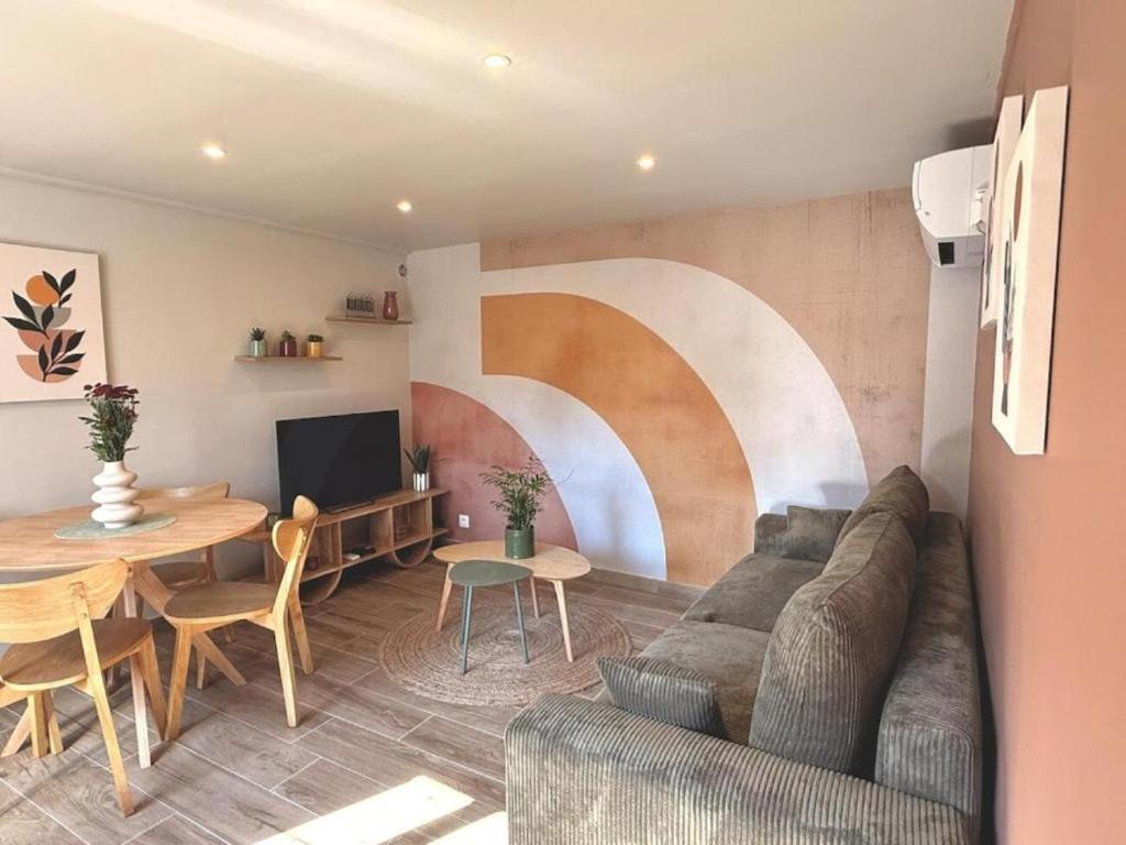 a living room with a couch and a table at Les Terres Beaujolaises in Belleville-en-Beaujolais