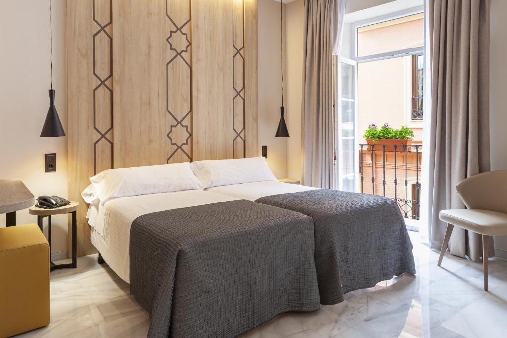 a bedroom with a bed and a large window at Porcel Navas in Granada