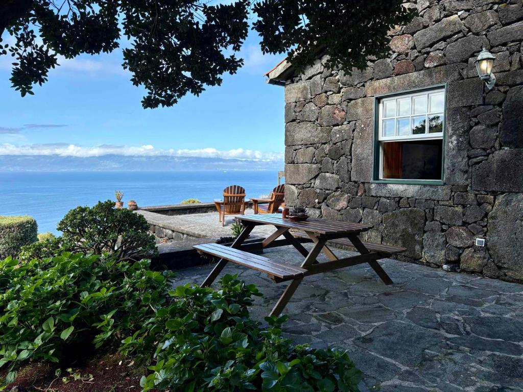 a wooden picnic table sitting outside of a stone building at Casa da Terra Alta in Santo Amaro
