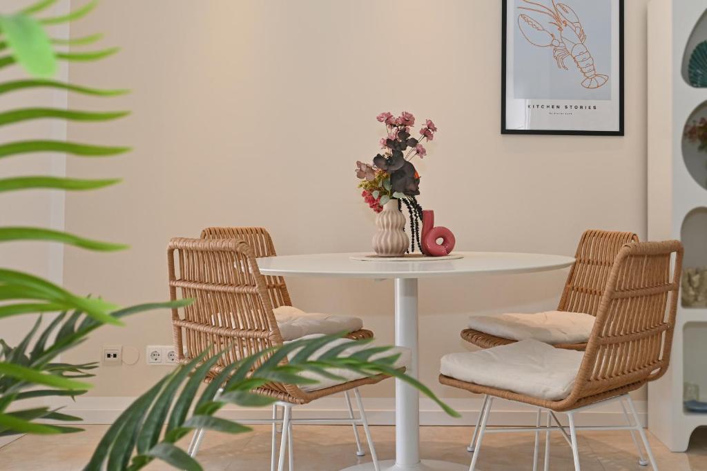 a white table with chairs and a vase of flowers on it at Casa Dalmatia in Krvavica