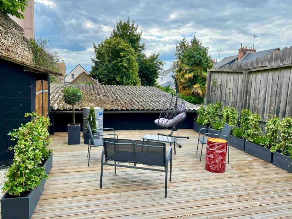 a patio with chairs and a hammock on a building at Appart Hotel NuitéeJour Le Mans Centre Jaurès in Le Mans