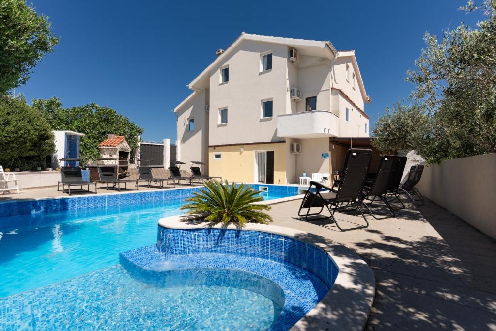 a house with a swimming pool in front of a building at Vila Martina in Novalja