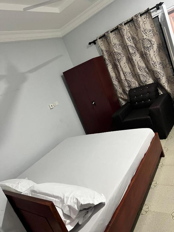 a bedroom with a bed and a chair at Esthemers Royal Hotel in Brunkum