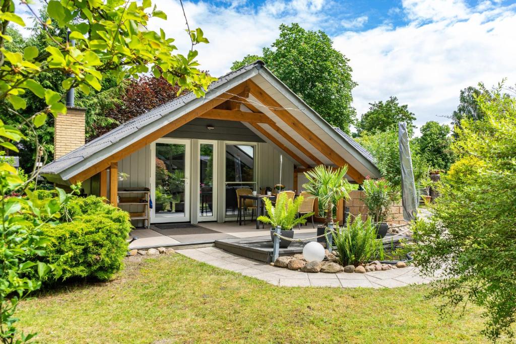 a small cottage with a patio in a garden at Elfenwinkel am See in Gartow