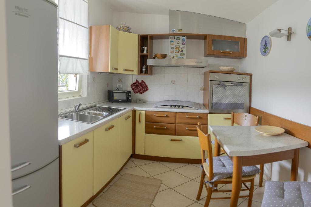 a kitchen with yellow cabinets and a table in it at La Bomboniera di Anna in Erba