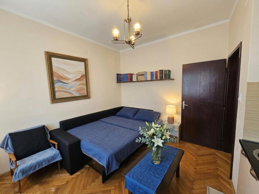 a bedroom with a bed and a couch and a table at Nexus Apartment in Podgorica