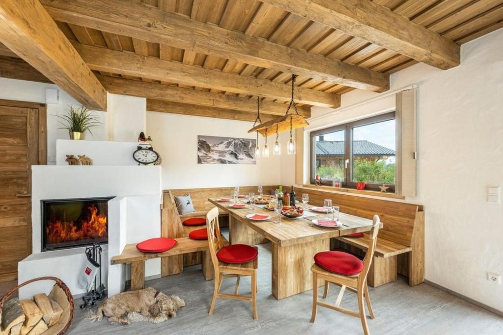a dining room with a table and a fireplace at Chalets Premium Dachstein in Forstau