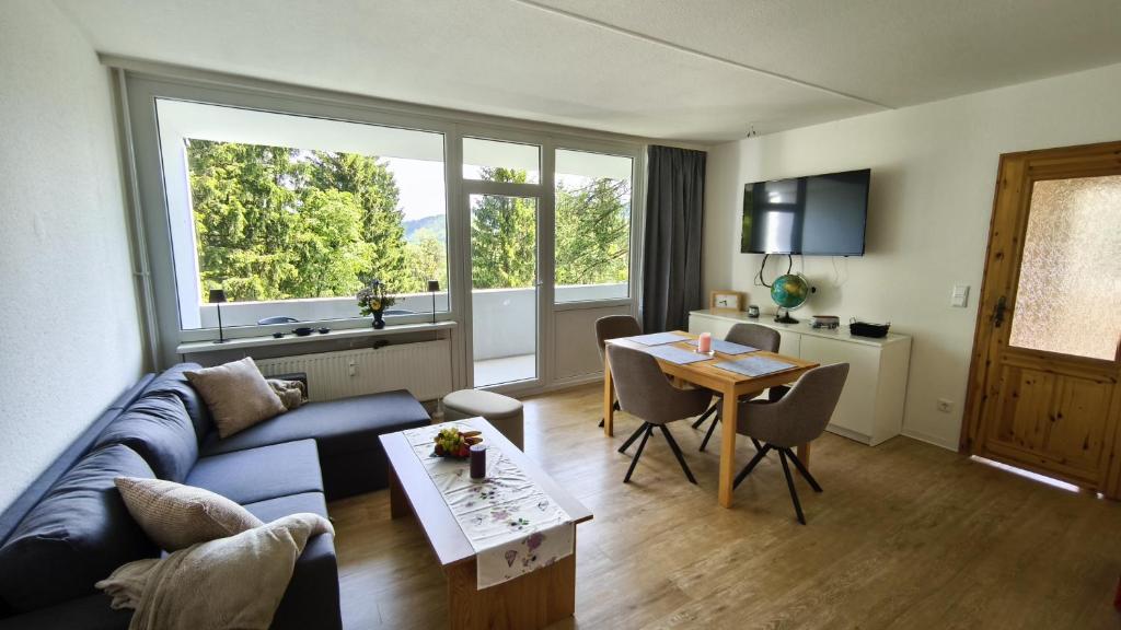 a living room with a blue couch and a table at HochDrei - Hahnenklee in Goslar