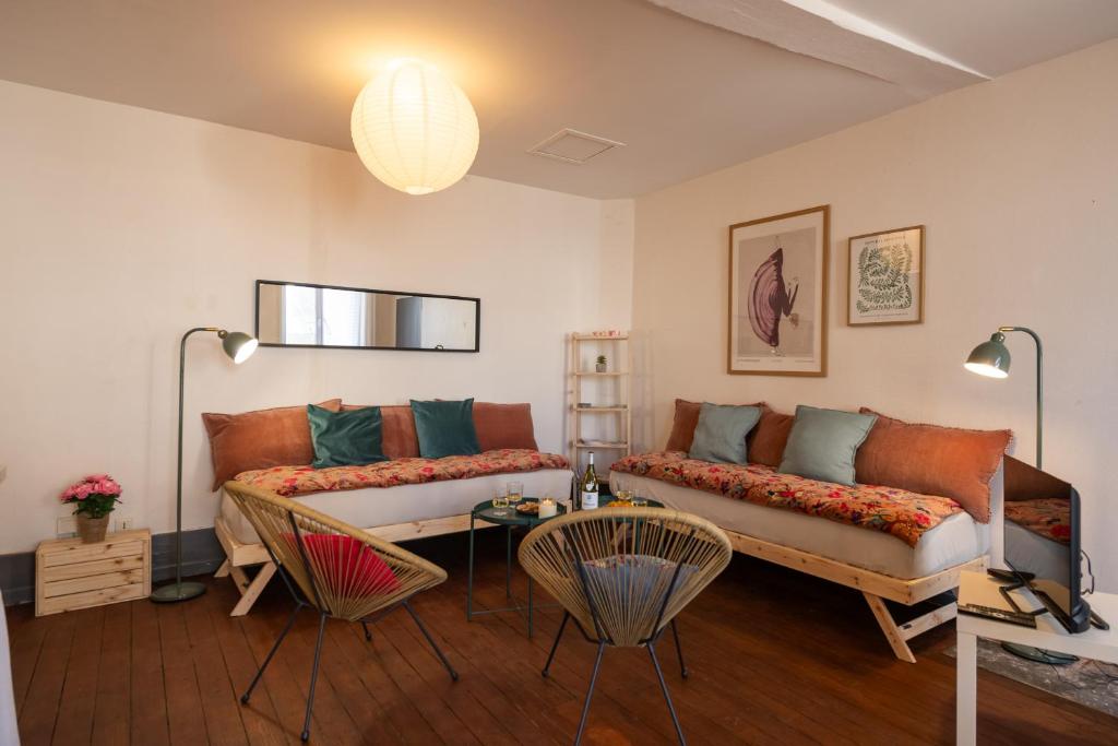 a living room with two couches and a table at a charming little apartment in Cluny