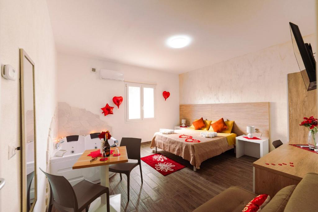 a hotel room with a bed and a table and chairs at Miluna Affittacamere in Siniscola