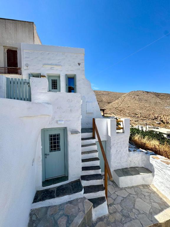 a white building with stairs and a door at NeSi Cycladic Living in Ano Syros