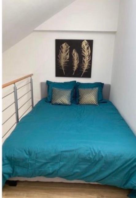 a bedroom with a blue bed with two pillows at Pomorie appartement ad in Pomorie