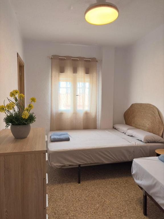 a small room with a bed and a window at Cala Queralt Rooms in Sagunto