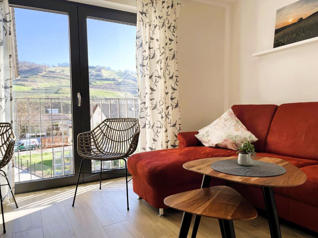a living room with a red couch and a table at Apartment Wendehals in Vogtsburg