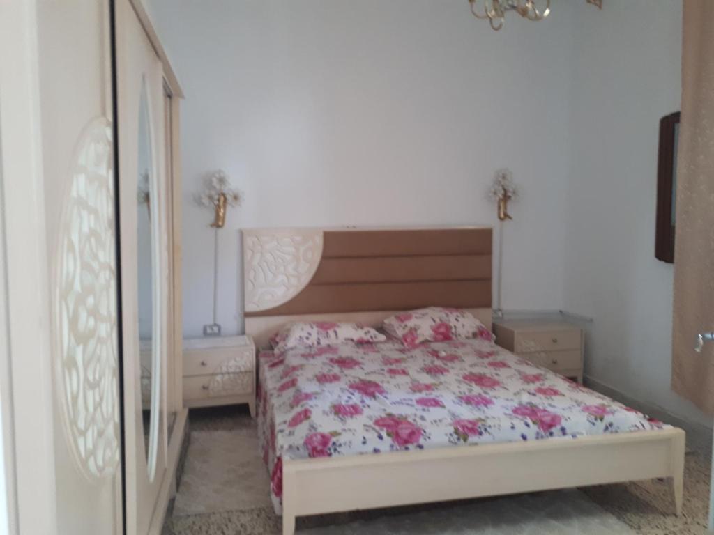 a bedroom with a bed with a floral bedspread at Belle vue in Aïn Draham