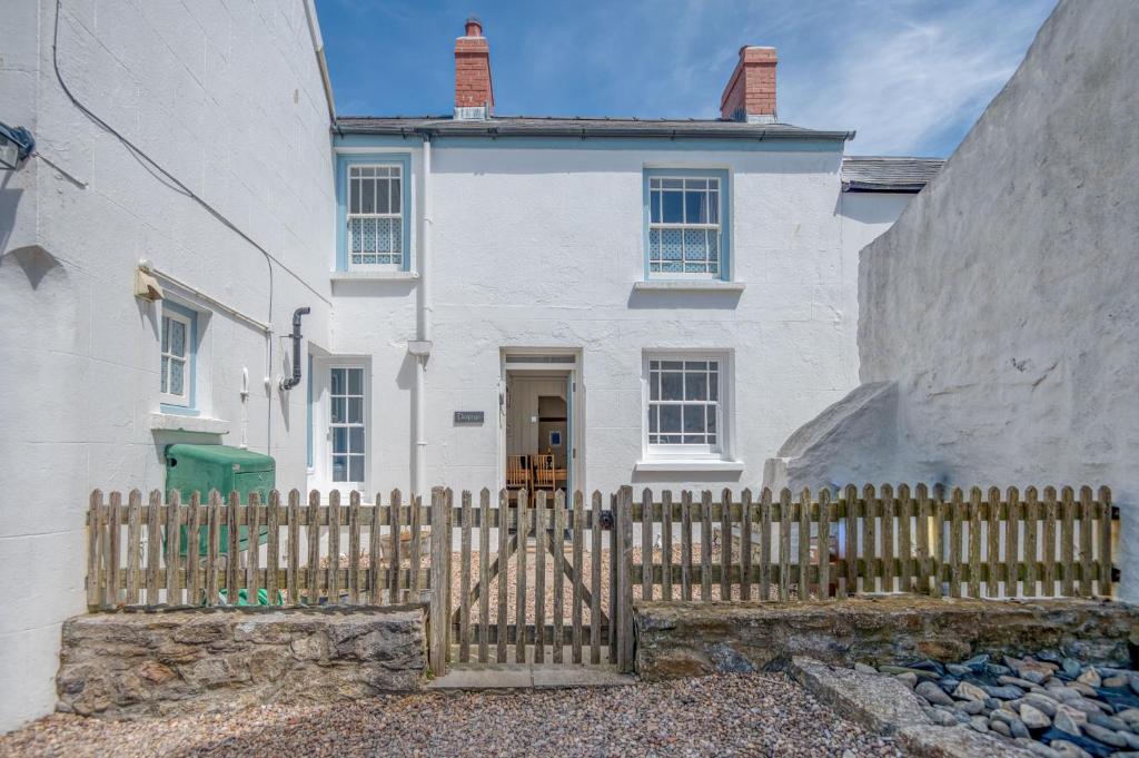 a white house with a fence in front of it at Delfryn in Tenby