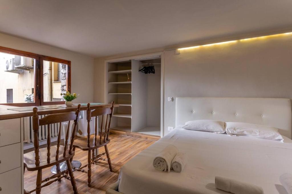 a bedroom with a bed and a kitchen with a table at Central Gucciardini house in Florence