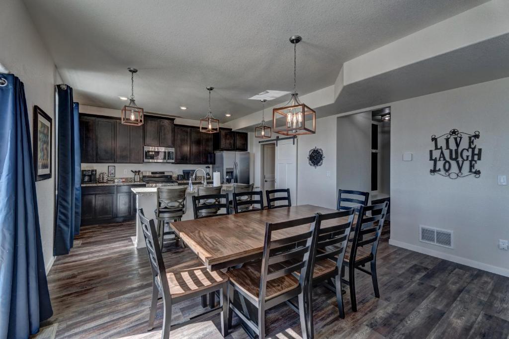 a kitchen and dining room with a wooden table and chairs at Executive Stay for Work & Family in Rapid City