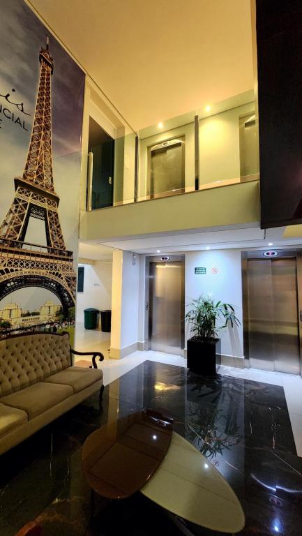 a living room with a couch and the eiffel tower at Estúdio Paris Lagoa Santa in Lagoa Santa