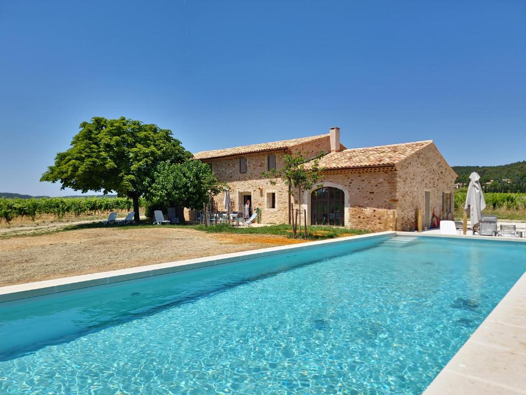 a villa with a swimming pool in front of a house at La Fabrique in Gargas
