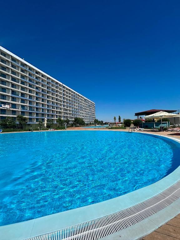a large swimming pool in front of a hotel at Studio Blaxy Mihnea in Douăzeci şi Trei August